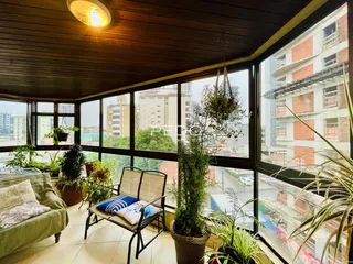 Sala de estar com vista para a cidade através de grandes janelas.