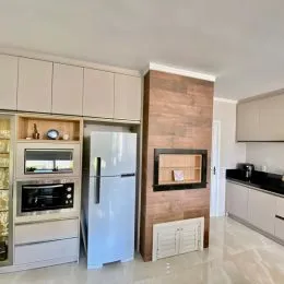 Cozinha com armários brancos e eletrodomésticos em aço inoxidável.