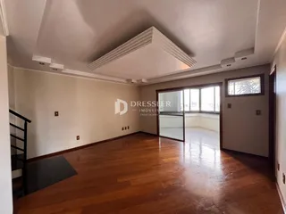 Sala de estar com piso de madeira polida e teto alto.