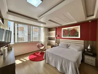 Quarto com piso de madeira e grande janela.