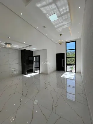 Sala de estar ampla com piso de mármore branco e teto com claraboia.