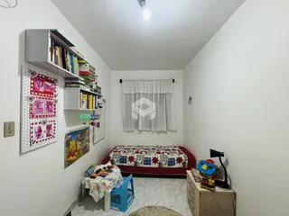 Quarto com estantes de livros e cama em um ambiente claro.
