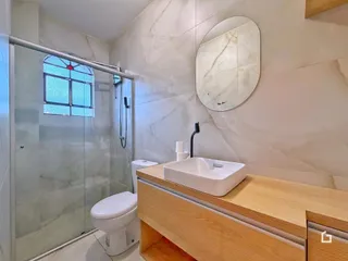 Foto de um banheiro moderno com box de vidro e revestimento de mármore.
