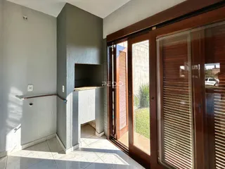 Hall de entrada com piso de cerâmica e portas de vidro.