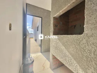 Vista de um corredor interno com acesso a uma área externa pavimentada.