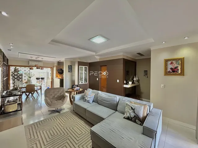 Sala de estar ampla com sofá e piso de madeira.