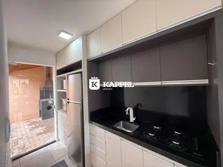 Esta é uma foto de uma cozinha moderna com armários cinzas e bancada preta.