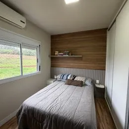 Quarto com cama e cabeceira de madeira.