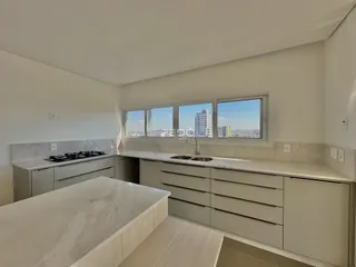 Vista da cozinha com armários e bancadas em mármore.