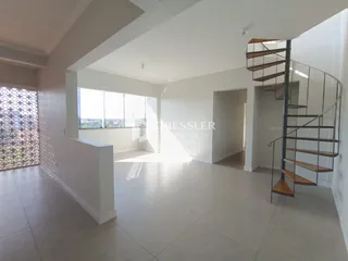 Sala de estar ampla com piso claro e teto alto.