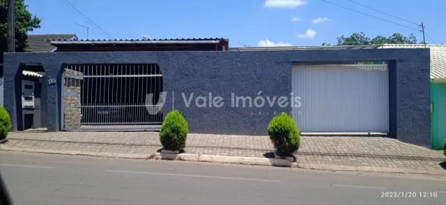 Fachada de uma residência com portão e porta de garagem.