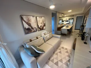 Sala de estar com sofá e quadros na parede.