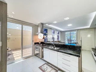 Cozinha moderna com bancada de granito e portas de vidro que dão acesso ao exterior.