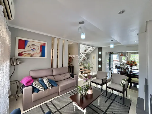 Sala de estar com sofá e poltronas em um apartamento.