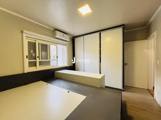 Quarto com armários e janela de madeira na residência.