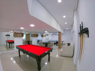 Interior de uma sala com piso claro e móveis.