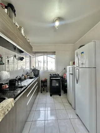 Foto de uma cozinha com armários e eletrodomésticos em um imóvel no Brasil.