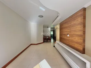 Hall de entrada com piso claro e parede de destaque em madeira.