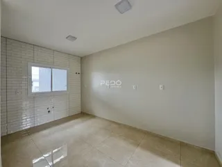 Foto de um corredor interno com piso de cerâmica e parede de tijolos brancos.