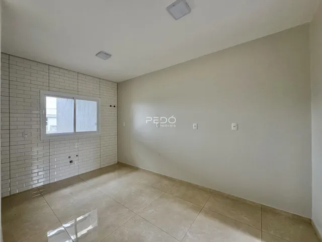 Foto de um corredor interno com piso de cerâmica e parede de tijolos brancos.