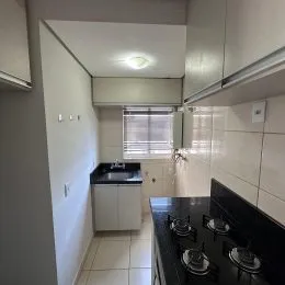 Foto de uma cozinha com armários brancos e bancada escura.