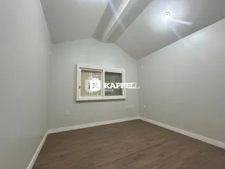 Sala de estar com paredes brancas e piso de madeira clara.