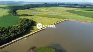 Vista aérea de uma paisagem rural com campos verdes e corpos d'água.