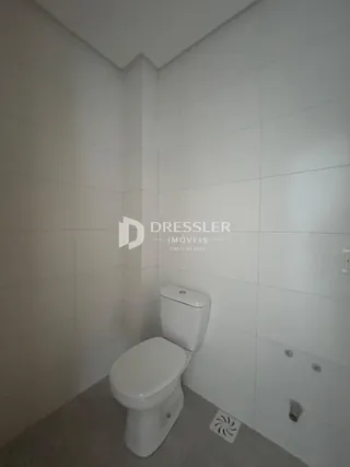 Foto de um banheiro interno com paredes brancas e piso claro.