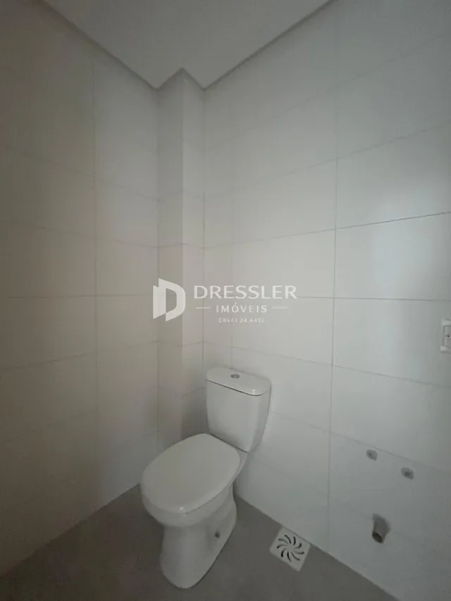 Foto de um banheiro interno com paredes brancas e piso claro.