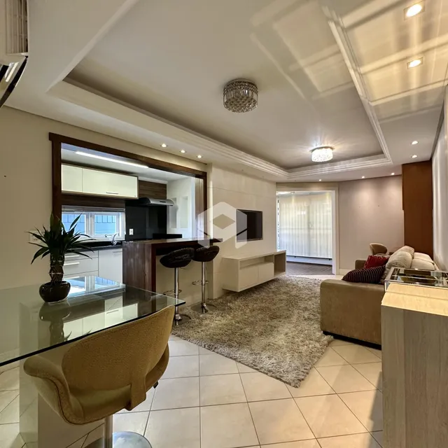 Ambiente de sala de estar com cozinha integrada e piso de cerâmica clara.