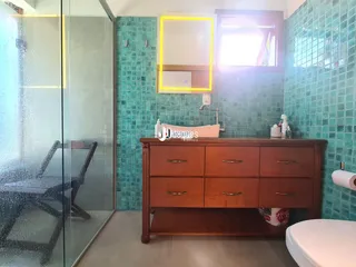 Foto de um banheiro com revestimento de azulejos turquesa e móveis de madeira.