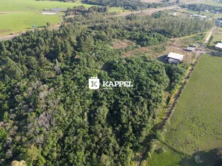 Vista aérea de uma propriedade com vegetação densa e áreas de campo.