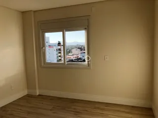 Ambiente interno com piso de madeira e janela de vista para a paisagem.