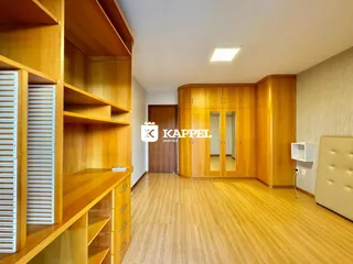 Sala de estar com painéis de madeira e piso de madeira clara.