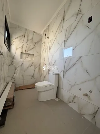 Foto de um banheiro com paredes de mármore branco na Lajeado.