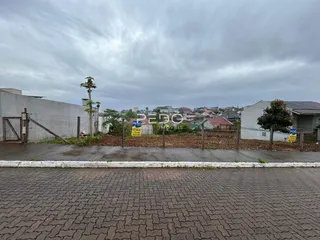 Vista da propriedade com cerca e terreno no fundo.