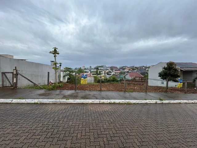 Vista da propriedade com cerca e terreno no fundo.