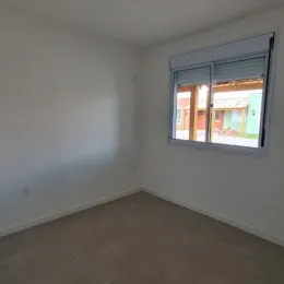 Foto de um cômodo interno vazio com paredes brancas.
