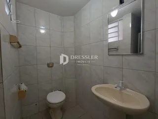 Foto de um banheiro com revestimento cerâmico claro.