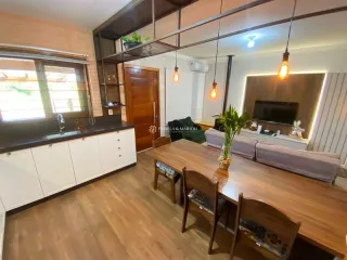 Mesa de madeira com cadeiras em um ambiente interno com piso de madeira.