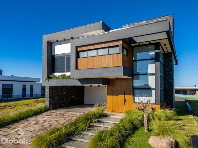 Fachada moderna de uma residência em Lajeado, Brasil, com acabamentos em madeira e pedra.