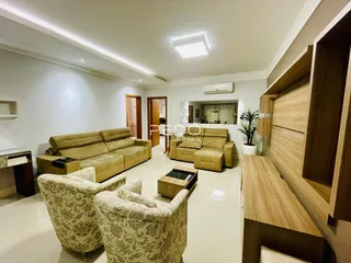 Sala de estar com sofá e poltronas em um ambiente claro.