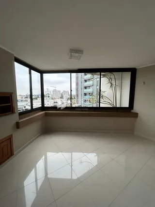 Sala de estar com grandes janelas que oferecem uma vista da cidade.