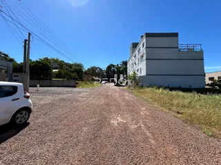 Vista externa de um imóvel com uma estrada de terra e vegetação ao redor.