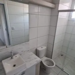 Foto de um banheiro com azulejos brancos e pia.