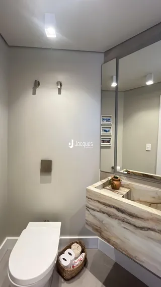 Foto de um banheiro moderno com bancada de mármore e vaso sanitário branco.