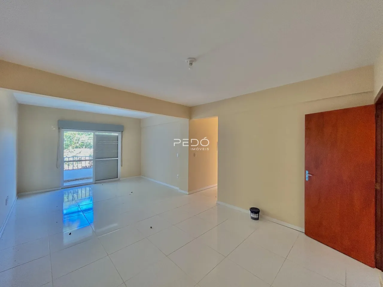Hall de entrada com piso de cerâmica e paredes claras em imóvel no Brasil.