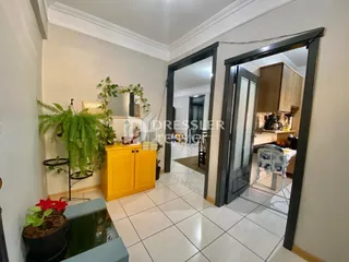 Interior de um ambiente com piso de cerâmica branca e portas de madeira.
