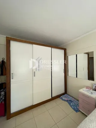 Quarto com armários embutidos brancos e piso de cerâmica.
