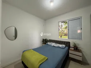 Quarto interno com cama e janela em uma residência.